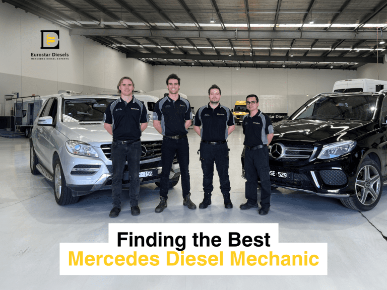 Four mechanics in black uniforms stand in a spacious auto repair shop next to two Mercedes vehicles, one silver and one black. A sign above reads "Eurostar Diesels." Text overlay at the bottom says "Finding the Best Mercedes Diesel Mechanic."